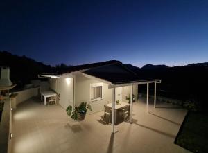 a house with a roof with a patio at night at Ornament: Infinite Nature Villa in Dhafnés