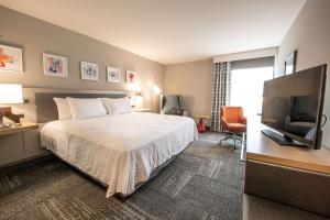 a hotel room with a bed and a flat screen tv at Hilton Garden Inn Asheville South in Asheville