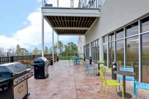un patio avec des chaises, des tables et un grill dans l'établissement Home2 Suites By Hilton Dickson City Scranton, à Dickson City