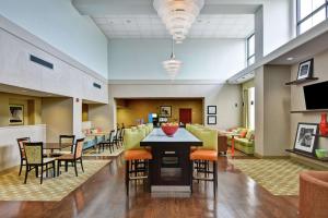 a lobby with chairs and a bar in the middle at Hampton Inn & Suites Wilkes-Barre in Wilkes-Barre