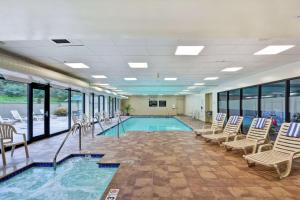 einen Pool mit Stühlen und einen Pool in der Unterkunft Hampton Inn & Suites Wilkes-Barre in Wilkes-Barre