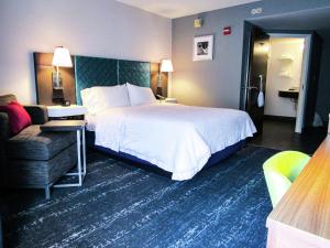 a hotel room with a large bed and a couch at Hampton Inn & Suites Newtown in Yardley