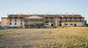 a large building with a field in front of it at Hotel-Asador Montes Oretanos in Pulgar