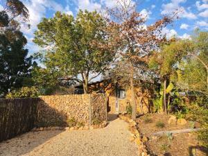 ein Steinhaus mit einem Zaun und einem Hof in der Unterkunft Stone Cottage Riebeek Valley in Riebeek-Wes