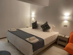a bedroom with a bed with two towels on it at Hotel Kourkoumelata in Argostoli +59 photos