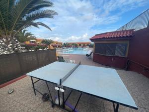 a blue ping pong table on a patio with a pool at Estrella marina home (suite) in Costa de Antigua