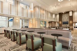 hol z poczekalnią ze stołami i krzesłami w obiekcie Homewood Suites By Hilton Hartford Manchester w mieście Manchester