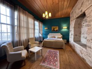 a bedroom with blue walls and a bed and chairs at Grace Lounge Suite in Antalya