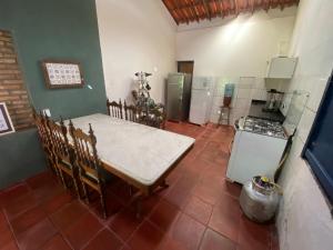 a kitchen with a table and chairs and a refrigerator at Solar dos Pássaros in Pacoti