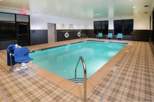 - une piscine dans un hôtel avec une chaise bleue dans l'établissement Hampton Inn Arvin Tejon Ranch, Ca, à Wheeler Ridge