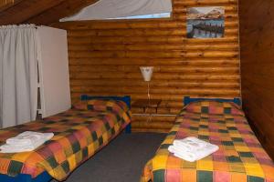 Zimmer mit 2 Betten in einem Blockhaus in der Unterkunft cabañas los Troncos in Junín de los Andes