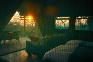 a room with a bedroom with a bed and a table at ZuriCamp - Tent Zahir in Tsumeb +7 photos