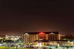 a hotel with a red sign on top of it at night at Hilton Garden Inn Bangor in Bangor