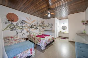 a bedroom with two beds and a flower mural on the wall at Pousada Luz do Jamacá in Chapada dos Guimarães