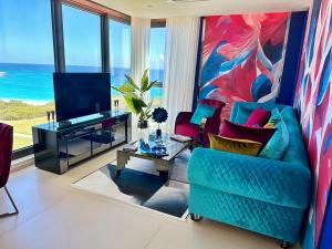 a living room with a blue couch and a tv at Mullet Bay Suites - Your Luxury Stay Awaits in Cupecoy
