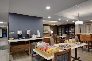 a restaurant with tables and chairs and a counter with food at Hampton Inn Birmingham-Colonnade 280 in Birmingham