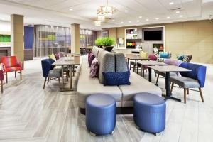 a restaurant with tables and chairs and a couch at Home2 Suites By Hilton Birmingham Colonnade in Birmingham