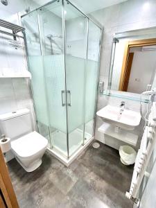 a bathroom with a shower and a toilet and a sink at Pensión Sarasate in Pamplona