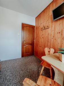 扎科帕內的住宿－Stan Relaksu - noclegi w Zakopanem，客房设有带桌椅的木墙