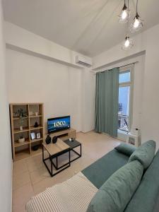 a living room with a green couch and a television at Domus Bettolo in Chania Town