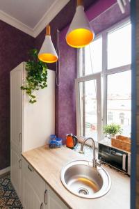 a kitchen with a sink and two lights above it at Austrian Lviv Apartments in Lviv