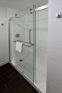 La salle de bains est pourvue d'une douche en verre et d'une serviette. dans l'établissement Hampton Inn Billings, à Billings