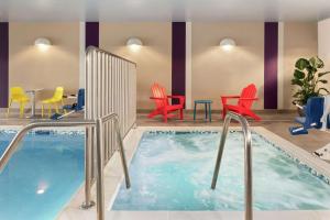 a pool in a hotel room with chairs and a table at Home2 Suites By Hilton Bismarck in Bismarck