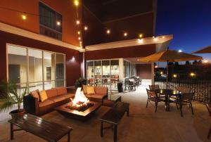 een patio met een bank en een vuurplaats bij DoubleTree by Hilton West Fargo Sanford Medical Center Area in Fargo