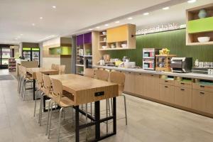 een keuken met tafels en stoelen in een winkel bij Home2 Suites By Hilton Bismarck in Bismarck