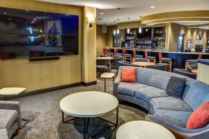 a waiting room with couches and a bar at DoubleTree by Hilton West Fargo Sanford Medical Center Area in Fargo
