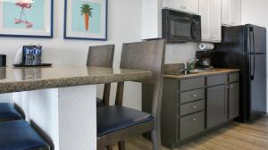 a kitchen with a counter and a sink and a refrigerator at Bilmar Beach Resort in St. Pete Beach