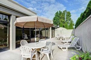 un patio con mesa, sillas y sombrilla en Hampton Inn Bloomsburg, en Bloomsburg