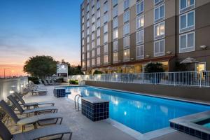 un hotel con piscina con sillas y un edificio en DoubleTree by Hilton Biloxi, en Biloxi