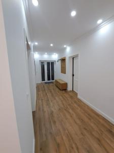 an empty room with white walls and wood floors at Apartament la casa in Bistriţa