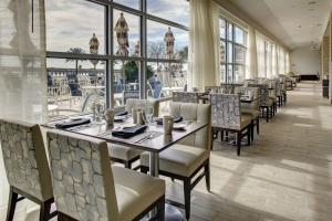 a dining room with tables and chairs and windows at DoubleTree by Hilton Biloxi in Biloxi