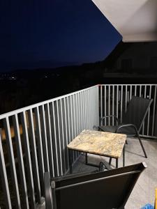 a table and chairs on a balcony at night at Apartament la casa in Bistriţa