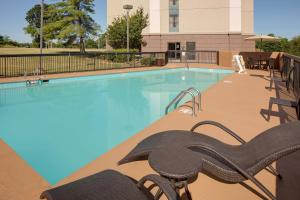 uma piscina com cadeiras ao lado de um edifício em Hampton Inn & Suites Nashville-Airport em Nashville