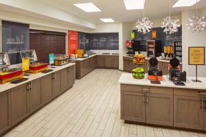 a large kitchen with wooden cabinets and a cafeteria at Hampton Inn & Suites Nashville-Airport in Nashville