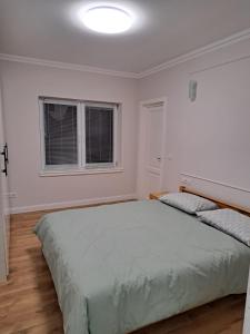 a bedroom with a large bed and two windows at Apartament la casa in Bistriţa