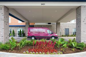 einem rosa Van vor einem Gebäude mit Blumen geparkt in der Unterkunft Hampton Inn & Suites by Hilton Nashville North Skyline in Nashville