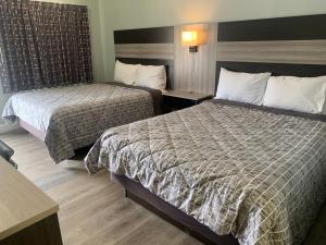 モントレーにあるモントレー オーシャンサ​​イド インのベッド2台とデスクが備わるホテルルームです。