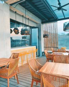 un restaurante con mesas de madera y sillas en una terraza en Eolia Sustainable Design Hotel, en Manta