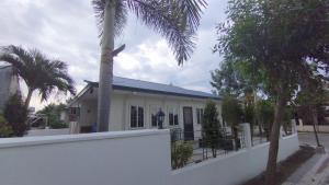 una casa con una palmera y una valla blanca en 2 Bedroom House in Bambu Estates Mintal Near Vista Mall and UP Mindanao en Dávao