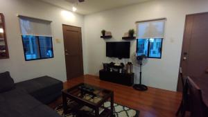 sala de estar con sofá y TV en 2 Bedroom House in Bambu Estates Mintal Near Vista Mall and UP Mindanao en Dávao