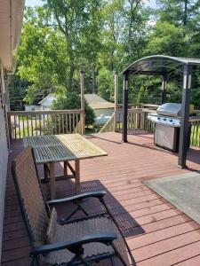 einen Picknicktisch und Stühle auf einer Terrasse mit Grill in der Unterkunft Southwoods Mountain Estate -private mansion, pool, hottub+ 15 acres in Monticello