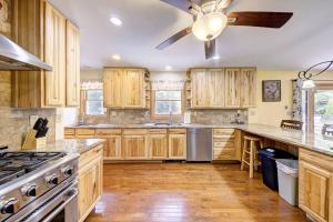 cocina con armarios de madera y ventilador de techo en Southwoods Mountain Estate -private mansion, pool, hottub+ 15 acres, en Monticello