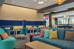 a restaurant with blue couches and tables and chairs at Tru By Hilton Meridian Boise West Id in Meridian