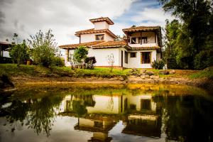 una casa sentada junto a un gran cuerpo de agua en El Pozzo Hotel Campestre, en Villa de Leyva