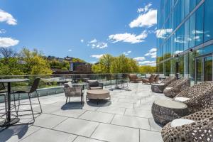 a patio with chairs and tables on a building at Hilton Garden Inn Boston Brookline, Ma in Brookline
