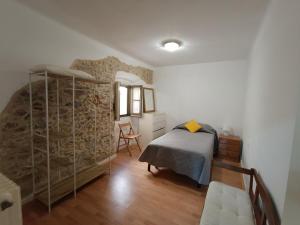 a bedroom with a bed and a stone wall at Apartamento en Terrades, Empordà in Terrades